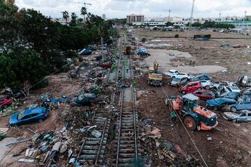 Coche y restos de la inundación amontonados en las vías del tren, en Alfafar, Valencia.