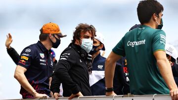 Max Verstappen, Fernando Alonso y Lance Stroll, de espaldas.