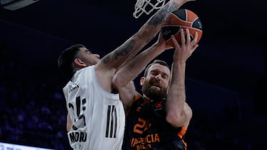 El jugador del Valencia Basket Matt Costello entra a canasta ante el jugador del Real Madrid Gabriel Deck (izda), durante el partido de la EuroLiga que Real Madrid y Valencia Basket disputan este jueves en el Movistar Arena, en Madrid.