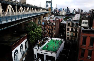 Una imagen aérea muestra the Ground, un edificio situado en Lower Manhattan (Nueva York) dedicado exclusivamente al fútbol, tanto en su interior como en los exteriores del recinto. En la azotea del inmueble un grupo de niños juega un partido junto a un mural gigante dedicado a tres leyendas: Diego Armando Maradona, Johan Cruyff y George Best.