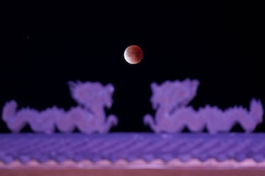 La 'Luna de Gusano' se eleva sobre la entrada principal de La Chinesca, el histórico barrio chino, durante un eclipse lunar total, en Mexicali, México.