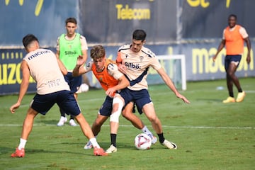 Carlos Fernández, con un aparatoso vendaje en su pierna derecha, junto a José Antonio de la Rosa en un entrenamiento en la Ciudad Deportiva.