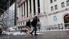 People walk through snow outside of the New York Stock Exchange (NYSE) in Manhattan on January 07, 2022 in New York City.