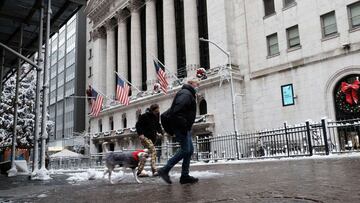 People walk through snow outside of the New York Stock Exchange (NYSE) in Manhattan on January 07, 2022 in New York City.