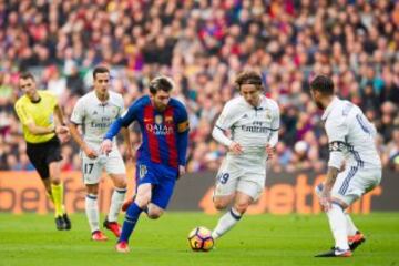 Lionel Messi tries to go around Luka Modric and Sergio Ramos