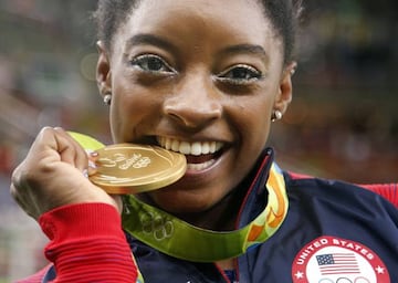 Simone Biles 'prueba' una de sus medallas de oro