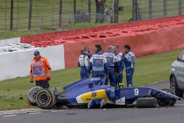 Ericsson (second left) receives medical treatment after he crashed his car during the third practice session at Silverstone.