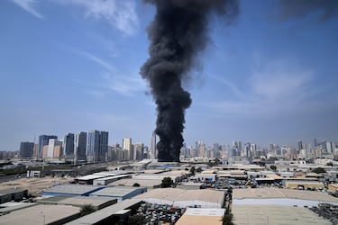 Una columna de humo negro se eleva desde un almacén en la zona industrial de Sharjah, Emiratos Árabes Unidos, tras los informes de ataques iraníes en Dubái.