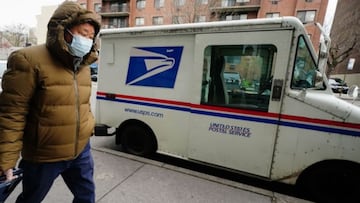 Un hombre con una m&aacute;scara que pasa por una camioneta de reparto del servicio postal de los Estados Unidos en el distrito de Queens en la ciudad de Nueva York, EE. UU., el 8 de abril de 2020. 