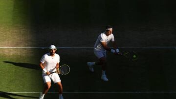 LONDON, ENGLAND - JULY 07: Robert Farah of Colombia (R) plays a backhand as partner Juan Sebastian Cabal of Colombia looks on against Mate Pavic of Croatia and Nikola Mektic of Croatia during their Men's Doubles Semi-Final match on day eleven of The Championships Wimbledon 2022 at All England Lawn Tennis and Croquet Club on July 07, 2022 in London, England. (Photo by Clive Brunskill/Getty Images)