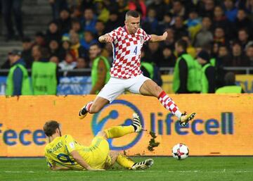 Croatia's Ivan Perisic jumps over Ukraine's Oleksandr Karavayev.