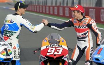 Los campeones del mundo de MotoGP, Marc Márquez, y de Moto2, Pol Espargaró (i) se saludan durante el posado que han realizado al término del Gran Premio de la Comunidad Valenciana, última carrera del Campeonato del Mundo, que se ha disputado hoy en el circuito Ricardo Tormo en Cheste (Valencia).