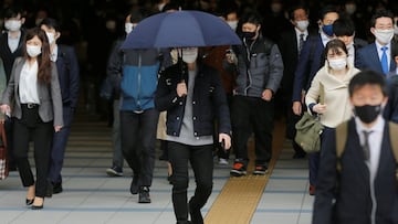 A man walks with an umbrella on a sunny day as commuters wear protective face masks amid the coronavirus disease (COVID-19) pandemic in Tokyo, Japan, April 6, 2021. REUTERS/Kim Kyung-Hoon
