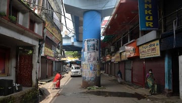 People walk along a deserted street after police personal orders to clear the area during a lockdown imposed until July 29 as a preventive measure against the spread of the COVID-19 coronavirus, in Siliguri on July 26, 2020. (Photo by Diptendu DUTTA and D