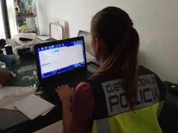 Polic&iacute;a comprobando uno de los dispositivos intervenidos durante el registro