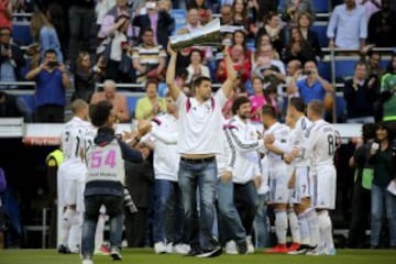 El ala-pívot del Real Madrid de Baloncesto Felipe Reyes levanta el trofeo que acredita al equipo campeón de la Euroliga de baloncesto, seguido por sus compañeros, a su entrada al estadio Santiago Bernabéu, para celebrar con la afición su triunfo, antes del partido de última joranda de Liga que el Real Madrid de fútbol y el Gerafe disputan esta tarde. 