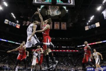 El jugador de San Antonio Spurs, Patrick Mills (8) trata de anotar ante el pívot de Portland Trail Blazers, Robin Lopez.