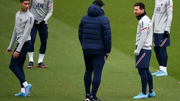 Paris Saint-Germain's Argentinian forward Lionel Messi (R) chats with Paris Saint-Germain's Argentinian head coach Mauricio Pochettino (C) during a training session at the Camp des Loges Paris Saint-Germain football club's training ground, in Saint-Germain-en-Laye, west of Paris on February 10, 2022. (Photo by FRANCK FIFE / AFP)