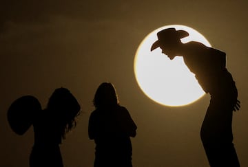 Personas silueteadas contra la luna llena el día del eclipse lunar en las Dunas de Samalayuca, en las afueras de Ciudad Juárez, México.