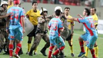 Los jugadores de Arsenal de Sarand&iacute; se enfrentan con la polic&iacute;a al finalizar el partido de la Libertadores ante Atl&eacute;tico Mineiro en Belo Horizonte (Brasil).