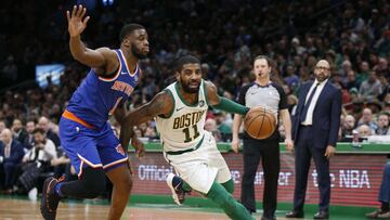 `Dec 6, 2018; Boston, MA, USA; Boston Celtics guard Kyrie Irving (11) drives past New York Knicks point guard Emmanuel Mudiay (1) during the second half at TD Garden. Mandatory Credit: Greg M. Cooper-USA TODAY Sports