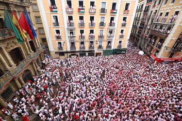 Personas se reúnen para celebrar durante el "Chupinazo", que marca el inicio oficial de las Fiestas de San Fermín en la Plaza Consistorial, frente al Ayuntamiento de Pamplona