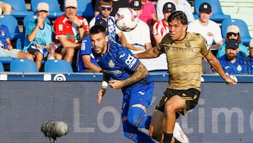 El delantero del Getafe Carles Pérez (i) pelea un balón con Jon Mikel Aramburu, de la Real Sociedad, durante el partido de LaLiga que se disputa este domingo en el Coliseo de Getafe. EFE/ Fernando Alvarado