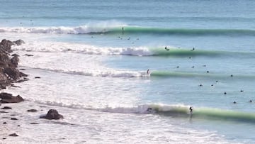 Cuatro olas rompiendo una tras otra en Cantabria, al lado de unos acantilados, con un surfista en cada una, en noviembre del 2022.