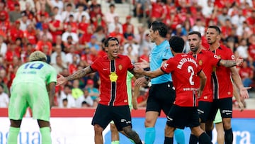 Real Mallorca players remonstrate with Spanish referee Jose Luis Munuera Montero during the Spanish league football match between RCD Mallorca and FC Barcelona at Mallorca Son Moix Stadium in Palma de Mallorca on August 16, 2025. (Photo by JAIME REINA / AFP)