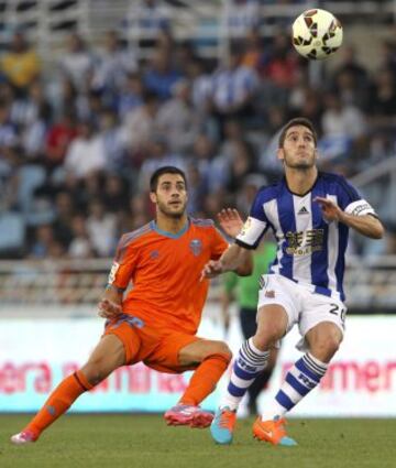 GRA314. SAN SEBASTIÁN, 28/09/2014.- El defensa de la Real Sociedad Joseba Zaldua (d) lucha un balón con el centrocampista del Valencia Carles Gil, durante el partido de la sexta jornada de Liga de Primera División disputado esta tarde en el estadio de Anoeta. EFE/Juan Herrero