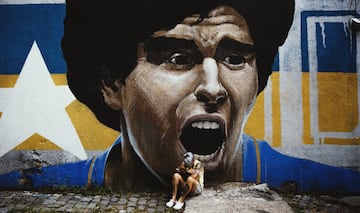 Una seguidora de Diego Armando Maradona llora su muerte delante de un graffiti suyo. 