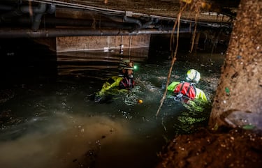 Varios bomberos buscando en los garajes afectados, en Alfafar, Valencia.