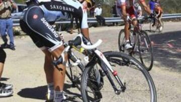 <b>PRIMER PERCANCE. </b>Contador, intentando soltar la rueda pinchada.