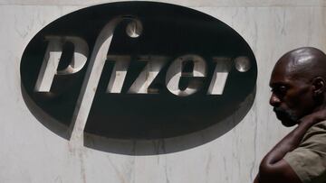 FILE PHOTO: A man walks past a sign outside Pfizer Headquarters in the Manhattan borough of New York City, New York, U.S., July 22, 2020. REUTERS/Carlo Allegri/File Photo