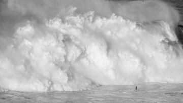 Un surfista frente a una de las olas gigantes que rompieron esta temporada en Nazar&eacute; (Portugal)