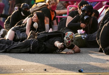 Manifestantes se refugian durante una protesta contra las redadas federales de inmigración en el centro de Los Ángeles.