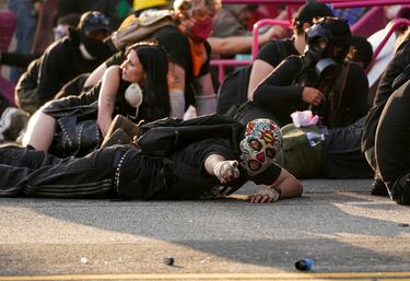 Manifestantes se refugian durante una protesta contra las redadas federales de inmigración en el centro de Los Ángeles.