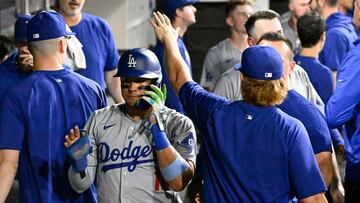Jun 24, 2024; Chicago, Illinois, USA; Los Angeles Dodgers shortstop Miguel Rojas (11), left, celebrates in the dugout after he scores against the Chicago White Sox during the seventh inning at Guaranteed Rate Field. Mandatory Credit: Matt Marton-USA TODAY Sports
