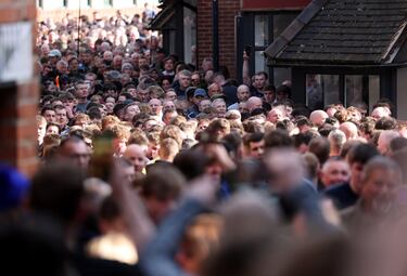 La gente camina por la calle en Ashbourne para seguir la pelota durante el partido anual de fútbol 'Royal Shrovetide'.