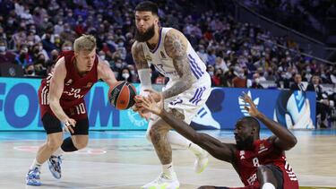 MADRID, 08/04/2022.- El pívot del Real Madrid Vincent Poirier (c) trata de jugar un balón entre Othello Hunter (d) y Ognjen Jaramaz, ambos del Bayern Múnich, durante el partido de la Euroliga de baloncesto que disputan este viernes en el WiZink Center, en