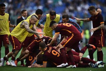 Roma players pile on Florenzi during the Rome derby