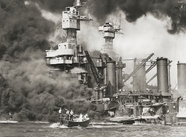 Los botes de rescate se acercan a los acorazados USS West Virginia (en primer plano) y USS Tennessee, que se encuentran a poca profundidad y arden tras el ataque sorpresa japonés a Pearl Harbor, Hawái.