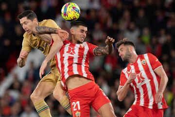 El delantero polaco del Barcelona, Robert Lewandowski, y el defensor español del Almería, Chumi, saltan por el balón durante el partido de fútbol de la Liga española entre la UD Almería y el FC Barcelona.