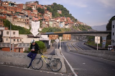 Un ciclista se detiene a revisar su teléfono, después de que el presidente de Estados Unidos, Donald Trump, dijera que Estados Unidos atacó a Venezuela.