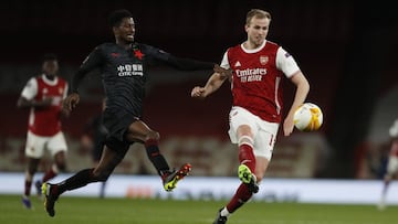 Arsenal's Rob Holding, right, passes the ball as Slavia Prague's Peter Olayinka tries to sop him during the Europa League quarterfinal soccer match between Arsenal and Slavia Prague at Emirates stadium in London, Thursday, April 8, 2021. (AP Pho
