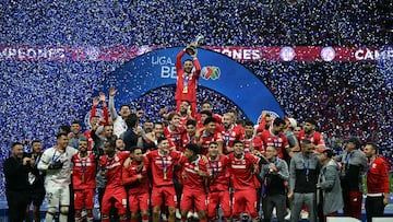 Toluca's forward #09 Alexis Vega lifts the trophy with teammates during a ceremony for the Mexican Champions following the Liga MX Clausura football tournament second leg final between Toluca and America at the Nemesio Diez stadium in Toluca de Lerdo, state of Mexico, Mexico on May 25, 2025. (Photo by CARL DE SOUZA / AFP)