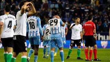 Los jugadores del M¨¢laga, cabizbajos tras perder ante el Racing.