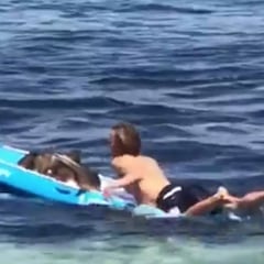 Un socorrista salva a un tiburón subiéndolo a su tabla y llevándolo de nuevo mar adentro