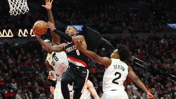 Portland Trail Blazers guard Damian Lillard (0) shoots over Utah Jazz forward Jarred Vanderbilt (8) and guard Collin Sexton (2) in the second half at Moda Center.