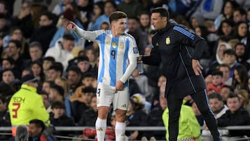 Argentina's coach Lionel Scaloni (R) gives instructions to forward Julian Alvarez during the 2026 FIFA World Cup South American qualifiers football match between Argentina and Chile at the Mas Monumental stadium in Buenos Aires on September 5, 2024. (Photo by JUAN MABROMATA / AFP)
